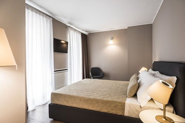 A modern hotel room with a bed, a desk, a chair, and a TV. - MYSWEETPLACE - Corso Como Apartments (Milan)
