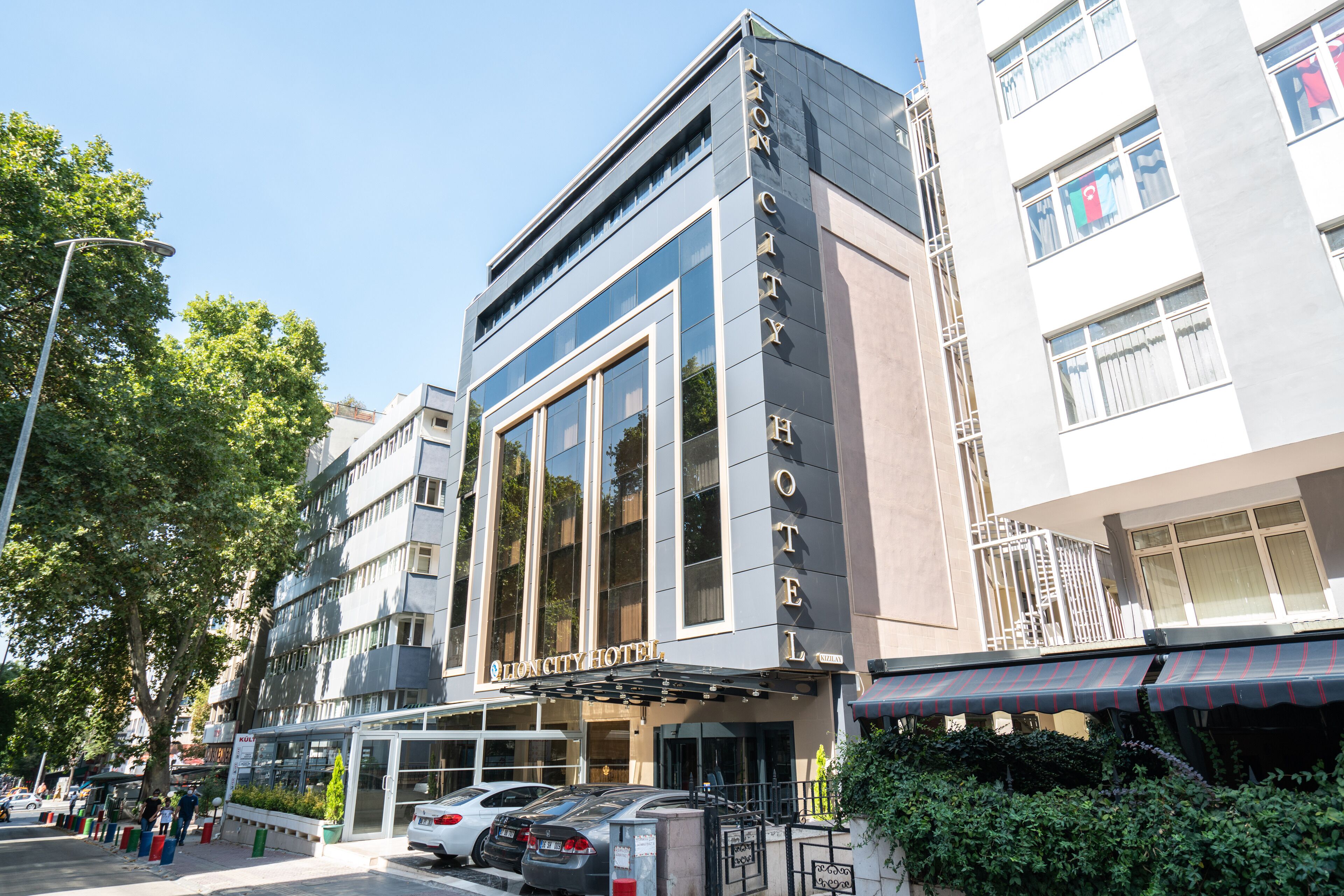 Un hôtel moderne doté d’une entrée imposante, de grandes fenêtres et offrant une vue dégagée sur la rue.