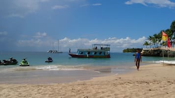 Gần bãi biển, cát trắng, ghế dài tắm nắng, dù trên bãi biển