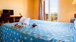 A hotel room with a bed, a desk with a computer, a TV, and a balcony with a view. - Hotel La Cava (Cabanes)