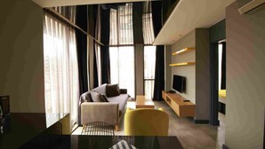 A modern hotel room with a sofa, a yellow armchair, a TV, and a large window with curtains. - Loft 1502 (Antalya)