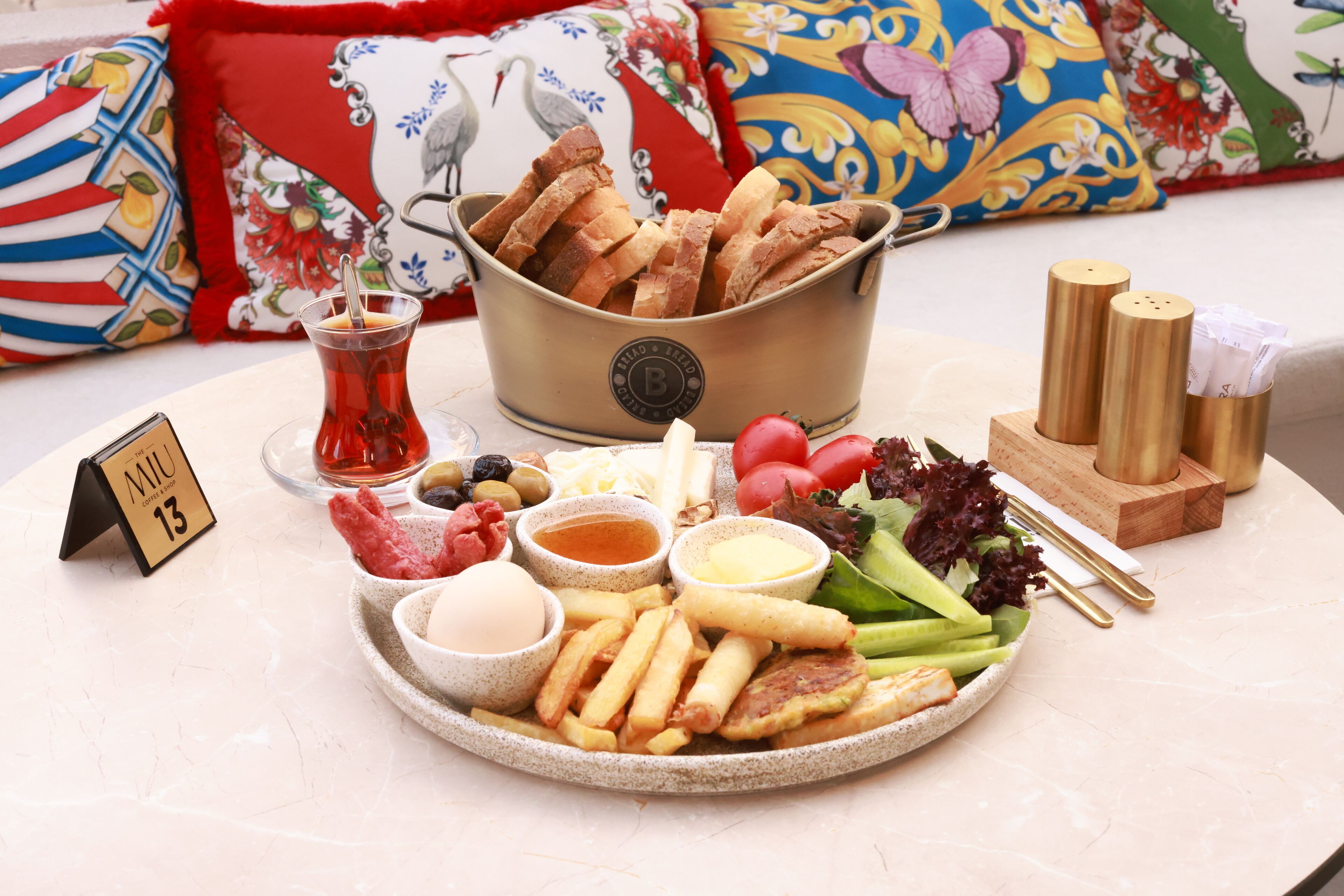 A table with a variety of food items including bread, salad, and sauces.