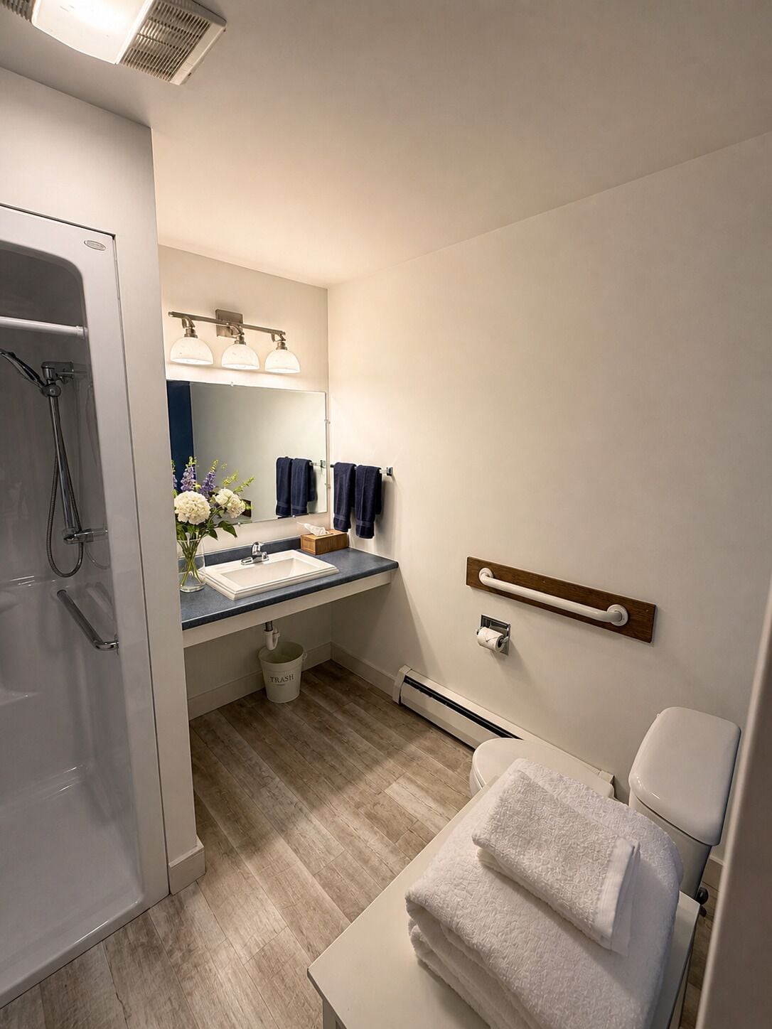 Une salle de bain moderne équipée d’une douche, d’un lavabo, de toilettes et d’un porte-serviettes.
