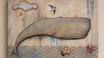 A whale, a bird, and a ship on a wooden background.