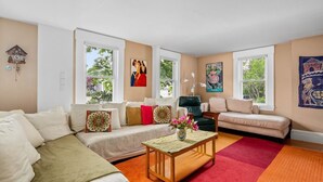 Ein Wohnzimmer mit einer Couch, einem Sessel und einem Couchtisch mit Blumen.