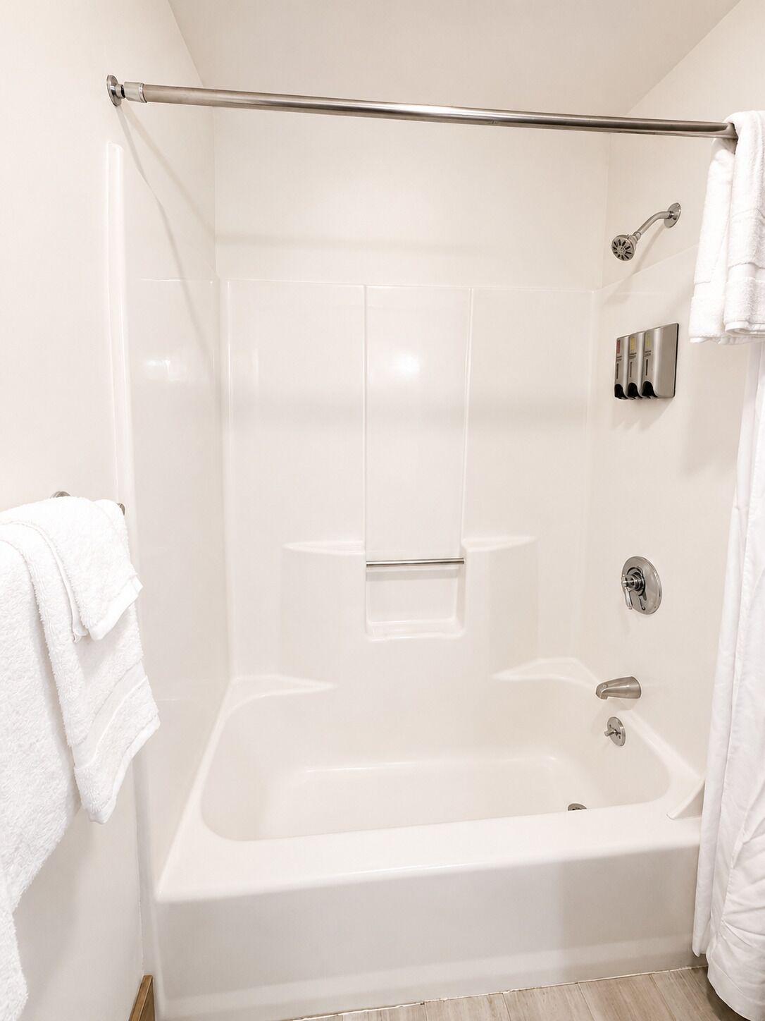 Ein modernes Badezimmer mit einer Badewanne, einer Duschkabine und einem Handtuchhalter.