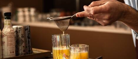 A bartender pouring a drink into a glass.