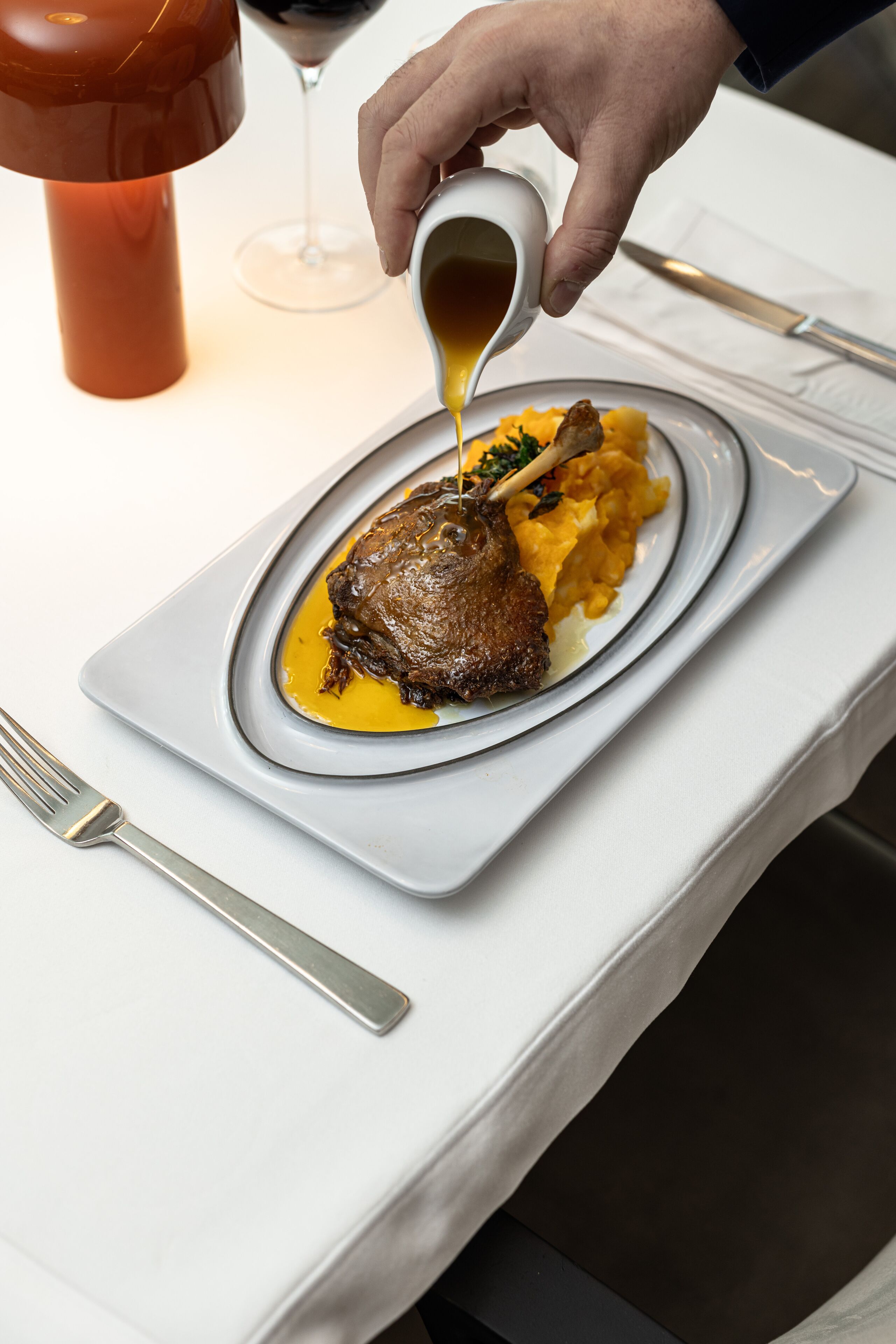A plate of food with a sauce being poured over it.
