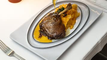 A plate of food with a sauce being poured over it.