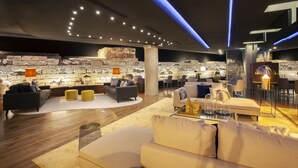 Ein moderner Lounge-Bereich mit Sofas, einem Couchtisch und einer Wand aus Stein.