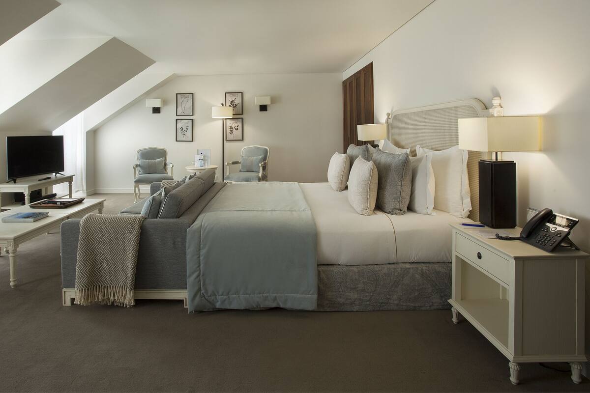 Une chambre d’hôtel moderne équipée d’un grand lit, d’un bureau, d’une chaise, d’une télévision et d’un téléphone.