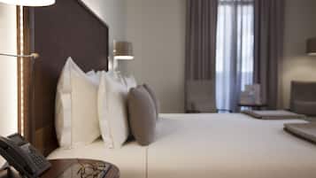 Una habitación de hotel con cama, lámparas de noche, un teléfono y un par de gafas sobre una mesita de noche.