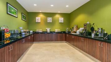 A modern kitchen with wooden cabinets, a black countertop, and various appliances.
