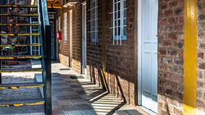 A corridor with a metal staircase, brick walls, and a white door marked with the number 5. - Posada los Tajibos (Puerto Iguazú)