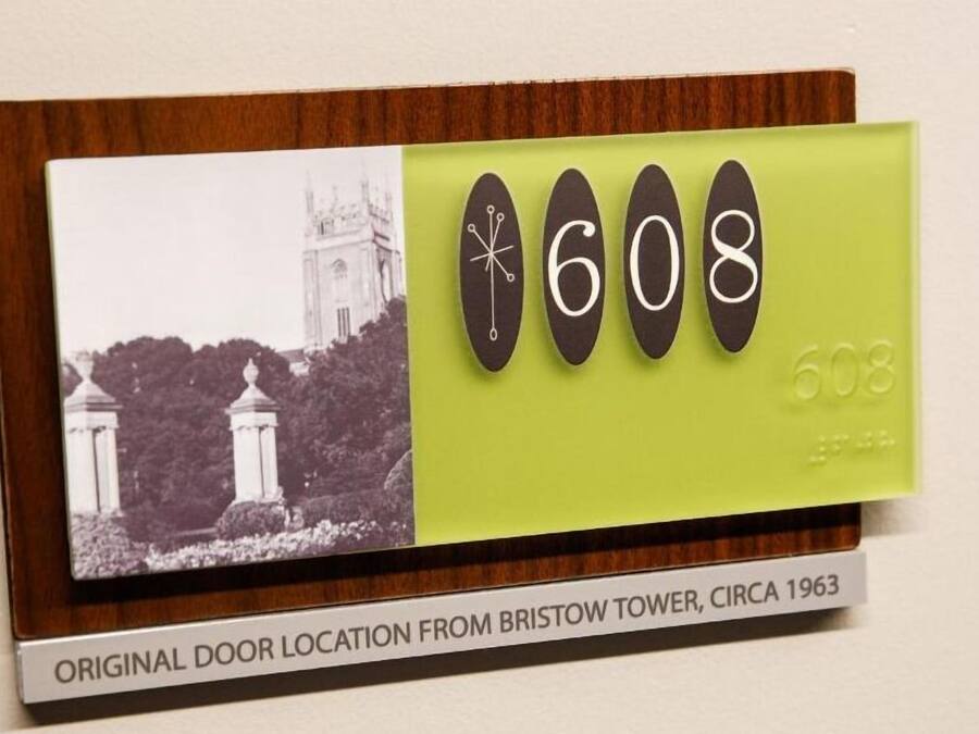 Uma placa com uma fotografia a preto e branco de uma torre e o número 608.