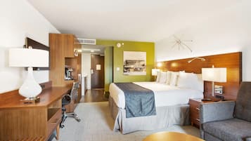Een hotelkamer met een bed, nachtkastjes, een bureau en een stoel.