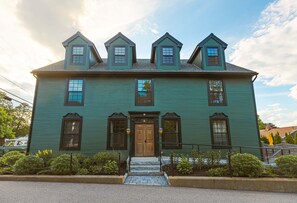 A two-story house with a central entrance, multiple windows, and a front porch. - Great Island Inn (New Castle)