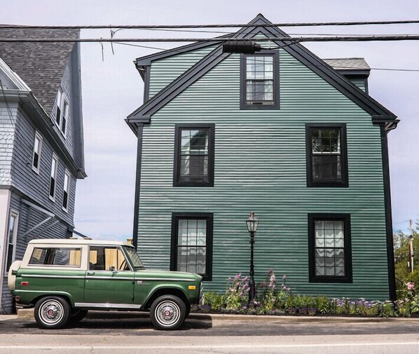 A green building with a gabled roof and multiple windows. - Great Island Inn (New Castle)