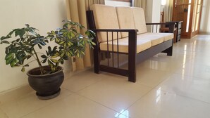 A modern living room with a sofa and a potted plant. - Tambo de Ollantay (Ollantaytambo)