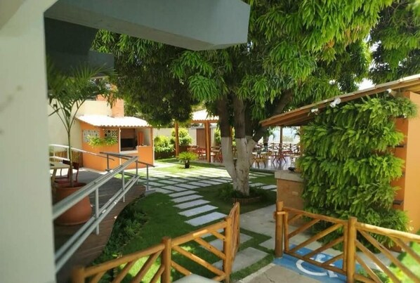 A courtyard with a wooden staircase, potted plants, and outdoor seating areas. - Grande Hotel de Juazeiro (Juazeiro)