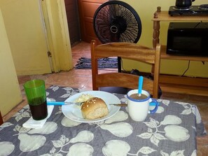 Une table à manger avec une assiette de nourriture, un verre avec une paille et un verre vert.