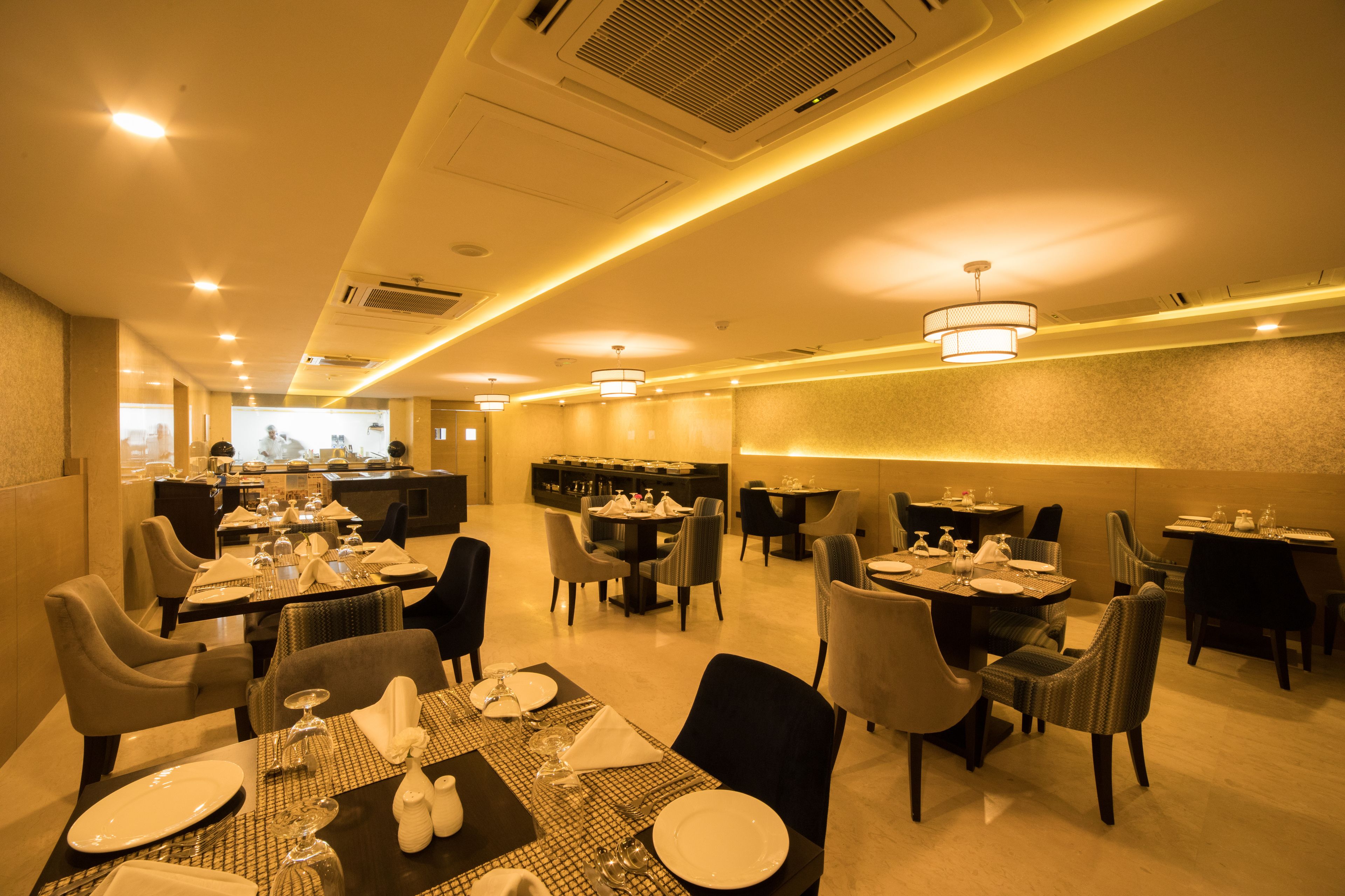 A hotel dining area with tables set for dining, chairs, and a bar in the background.