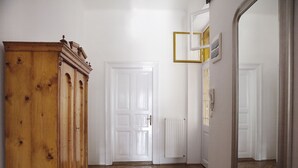 Ein Flur mit einem Holzschrank, weißen Türen und einem Spiegel.