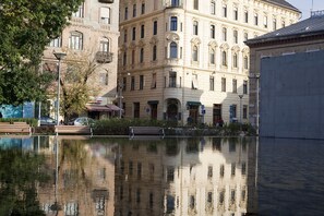 Un bâtiment à l’architecture classique, un bassin décoratif et un banc.