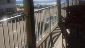 A balcony with a view of the sea and a parking area. - Crashing surf, steps to the sand, Pier BEST CONDO IN OLD ORCHARD BEACH (Old Orchard Beach)
