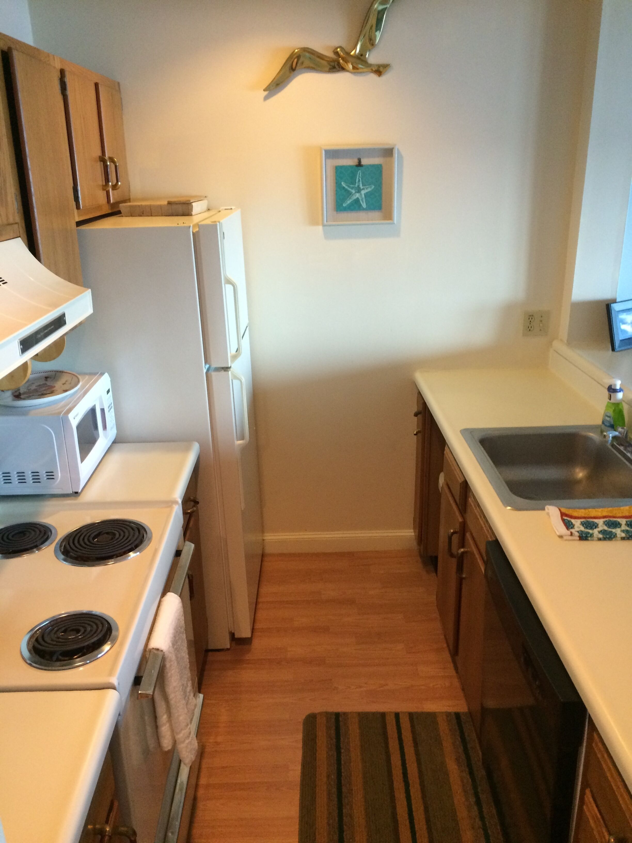 A compact kitchen with a microwave, toaster, and stove.