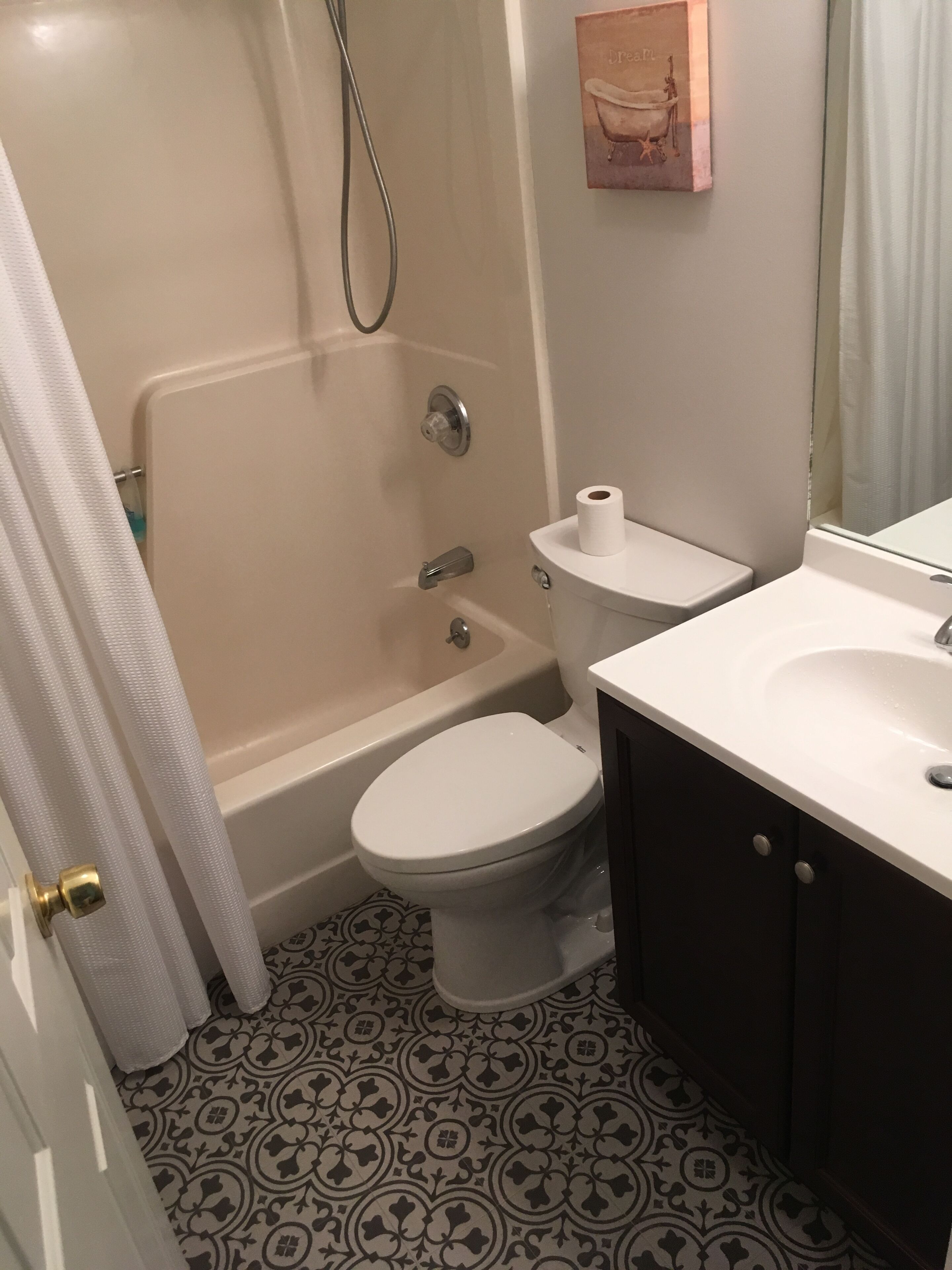 A bathroom with a toilet, sink, and bathtub.