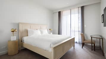 A bedroom with a bed, bedside tables, a chair, and a TV.