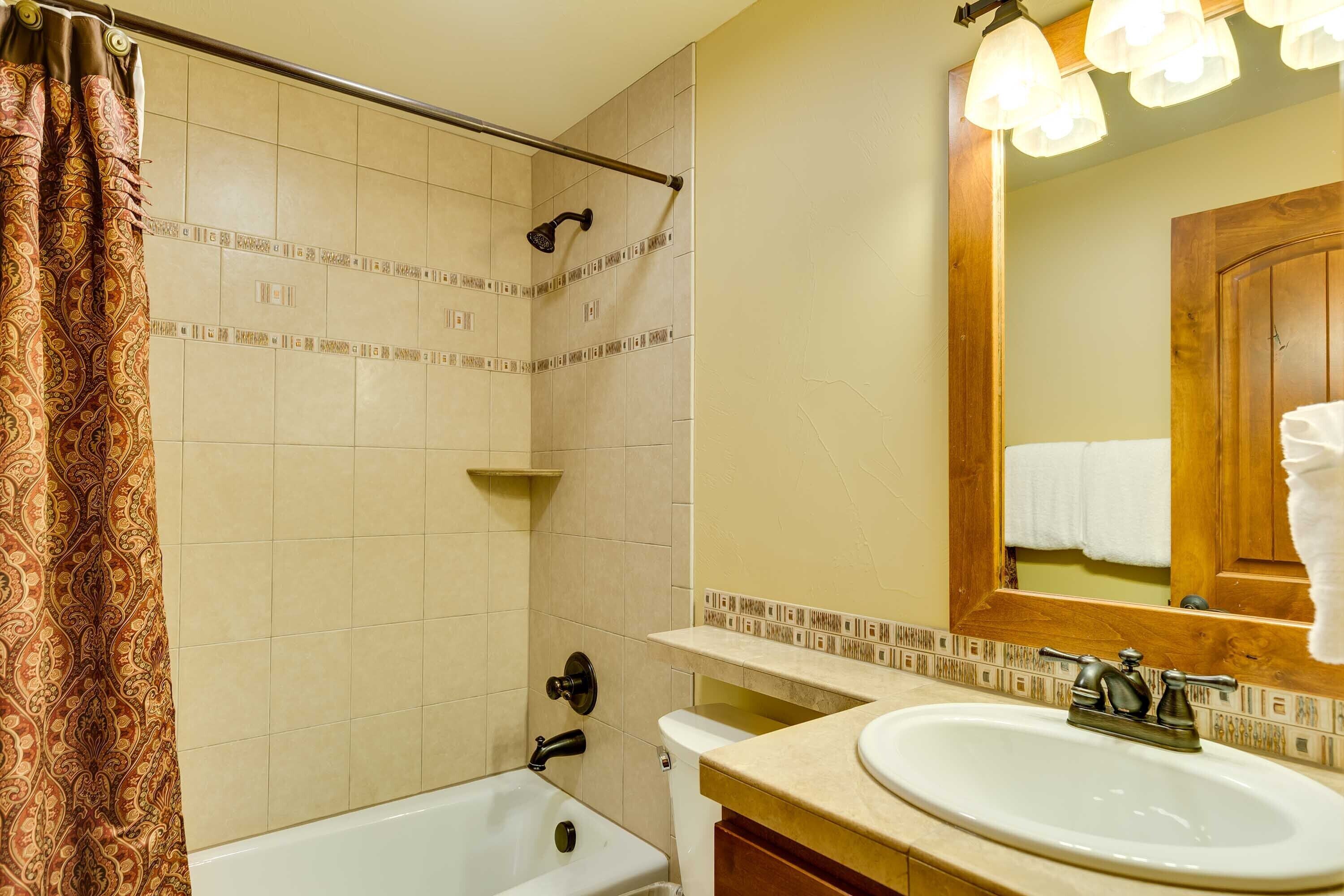 Een badkamer met een bad, een wastafel en een douche.