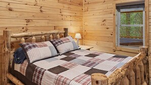 Una habitación de cabaña de madera con una cama, una ventana y una lámpara.
