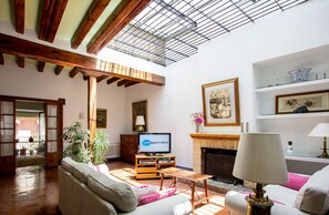 A spacious living room with a fireplace, a television, and a sofa.
