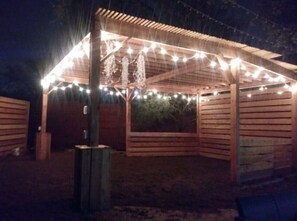 A covered outdoor area with string lights and wooden walls. - Bachelor Pad 18 beds, Golf, Pool, Pickleball, 5min to 6th street (Austin)