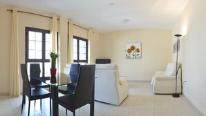 A modern living room with a dining area, featuring a glass table, chairs, a sofa, and a floor lamp. - CASA YOEL "PRIVACY, WARMTH, GUARANTEED REST, IDEAL FOR FAMILIES, NEW !!! (Granadilla)