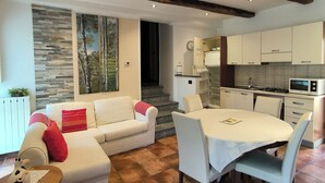 Un salon moderne avec un canapé, une table à manger et une cuisine en arrière-plan.