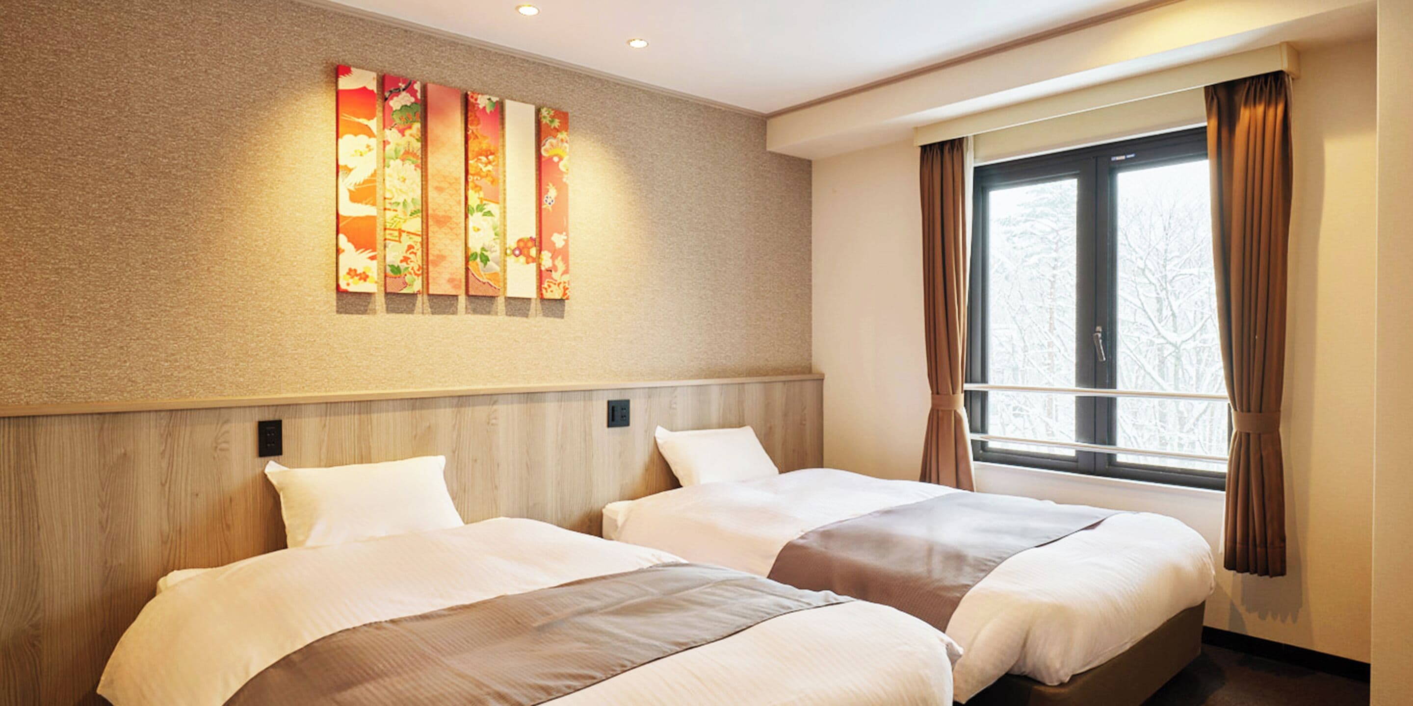 A hotel room with two beds, a large window with curtains, and a wall-mounted artwork.