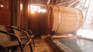 A wooden sauna room with a large wooden barrel, a stone-lined pool, and wicker chairs. - Hotel Abest Happo Aldea (Hakuba)