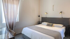 Ein Hotelzimmer mit Bett, Schreibtisch und Stuhl.