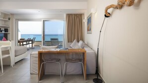 Ein Hotelzimmer mit Balkon, Essbereich und Meerblick.