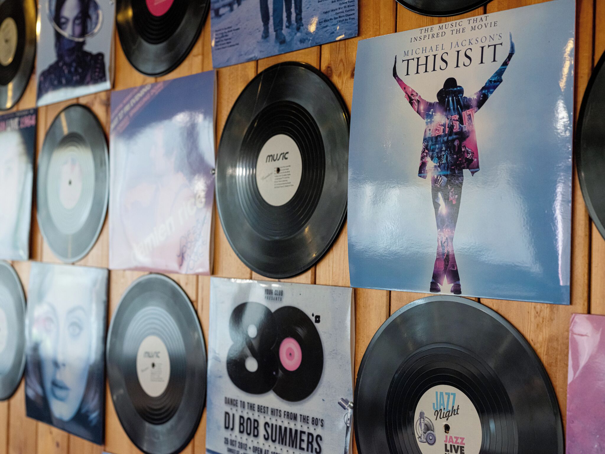 A wall of vinyl records with album covers, including 'This Is It' by Michael Jackson and 'Jazz Night Live' by DJ Bob Summers.