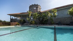 Una piscina con un edificio in pietra sullo sfondo.