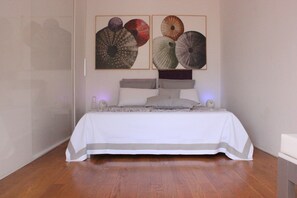 Ein Schlafzimmer mit einem Bett, Kissen, einem Kopfteil und einem Wandbild.