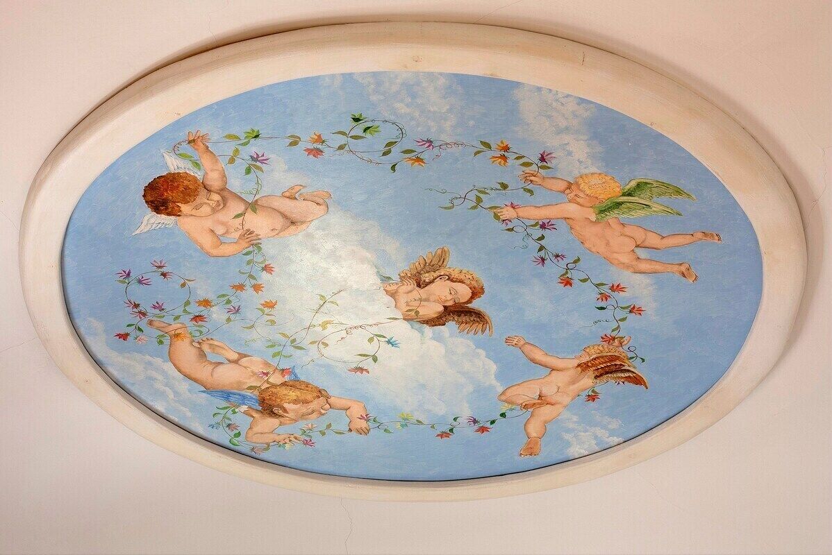 A circular ceiling mural with cherubs and floral designs.