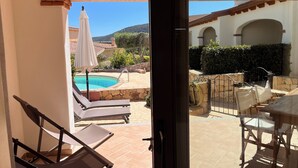 A view from a balcony overlooking a swimming pool, lounge chairs, and a patio area with outdoor furniture. - Residenza Limpiddu with Swimming Pool - Ground Floor - All Comforts  (Limpiddu)