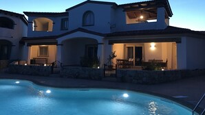 A two-story house with a swimming pool, outdoor seating area, and a covered patio. - Residenza Limpiddu with Swimming Pool - Ground Floor - All Comforts  (Limpiddu)