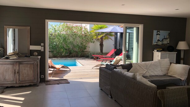 A modern living room with a pool, a dining area, and a view of the outdoors.