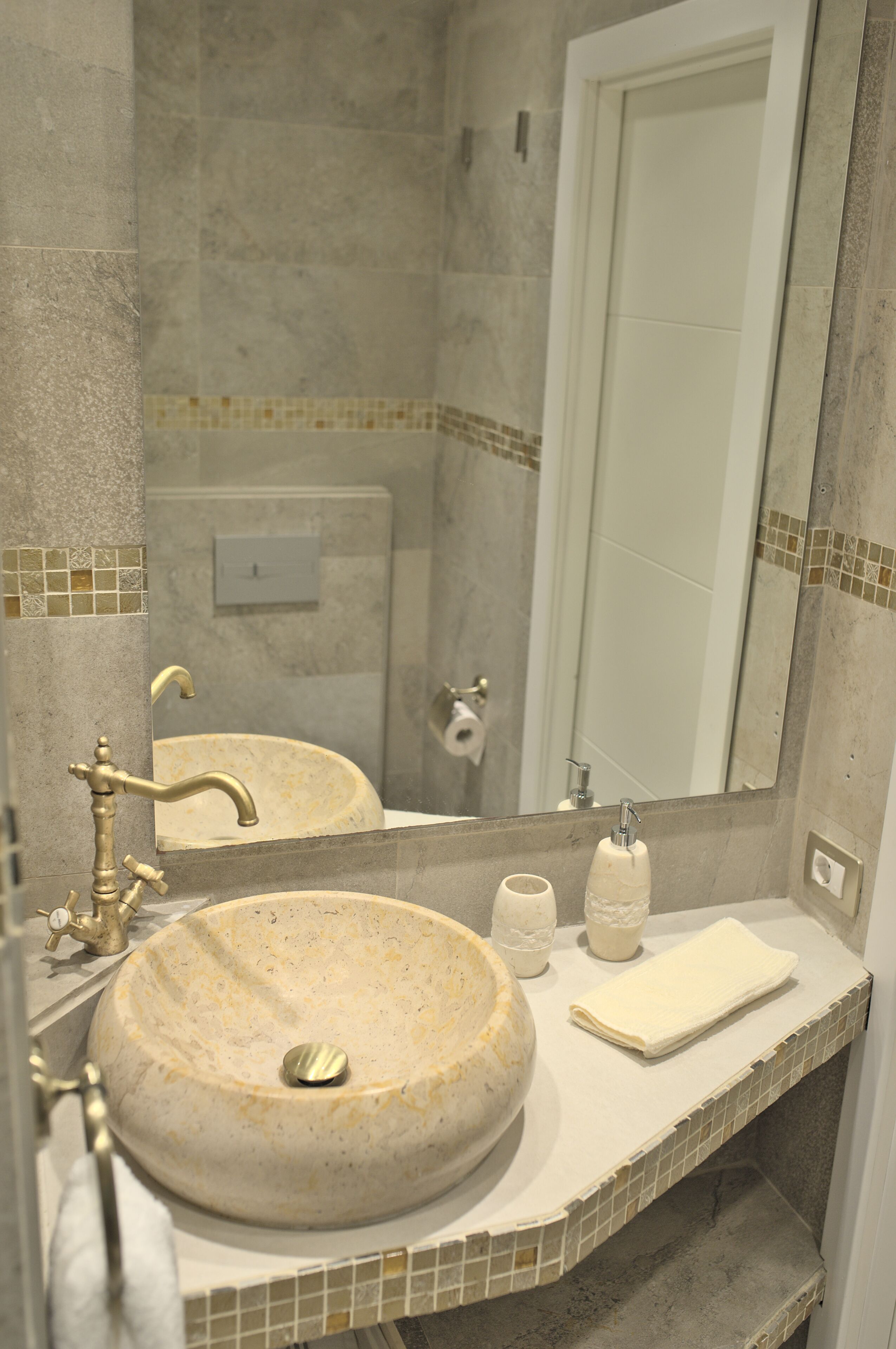 Une salle de bain avec un lavabo rond, un miroir et une serviette posée sur le comptoir.
